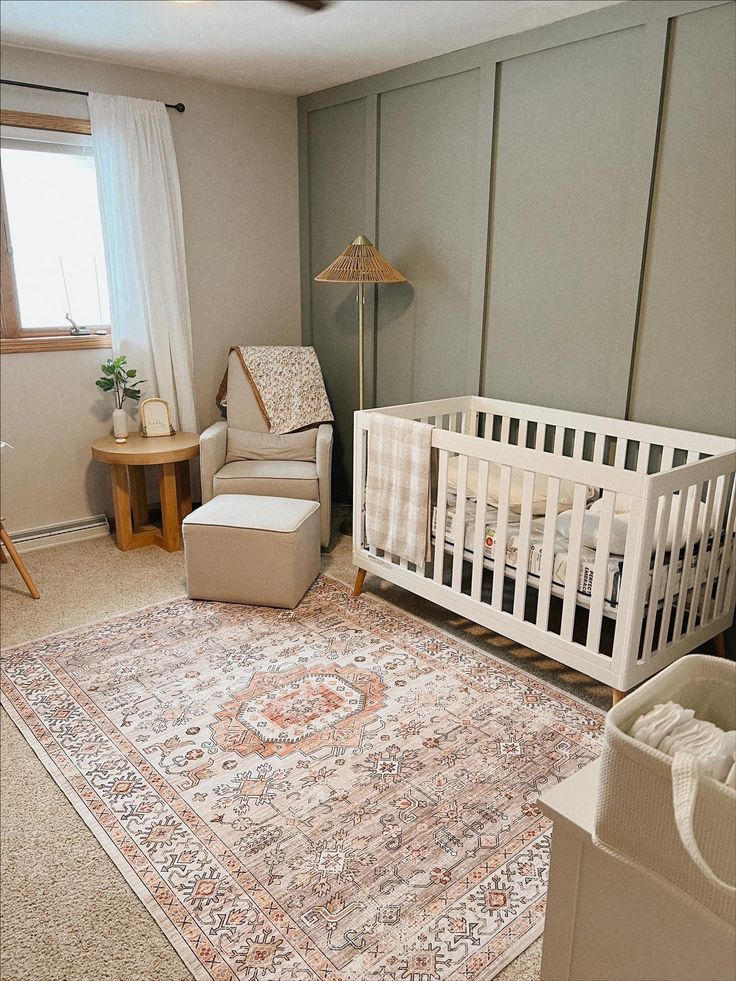 a baby's room with a crib, chair and rug