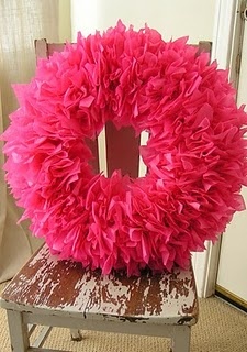 a pink wreath sitting on top of a wooden chair