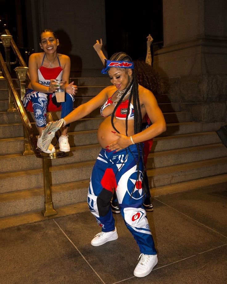 two women dressed in costumes standing on steps