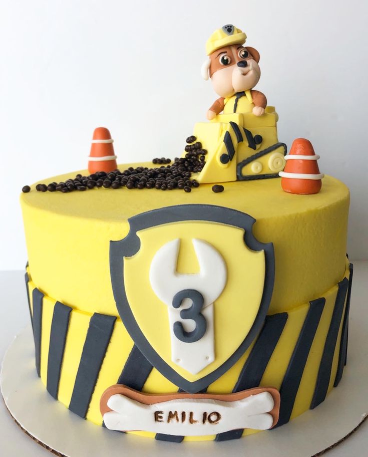 a yellow and black cake with a dog on top