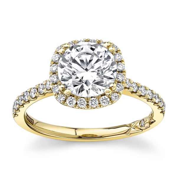 a yellow gold engagement ring with an oval cut diamond surrounded by round brilliant pave diamonds