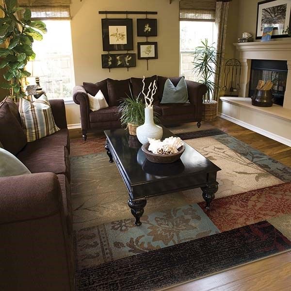 a living room with couches, tables and pictures on the wall in it's corner