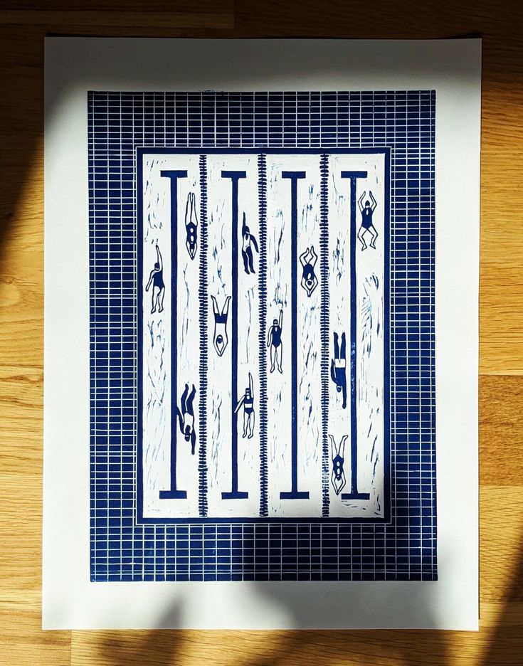 a blue and white print with lines on the bottom, in front of a wooden floor