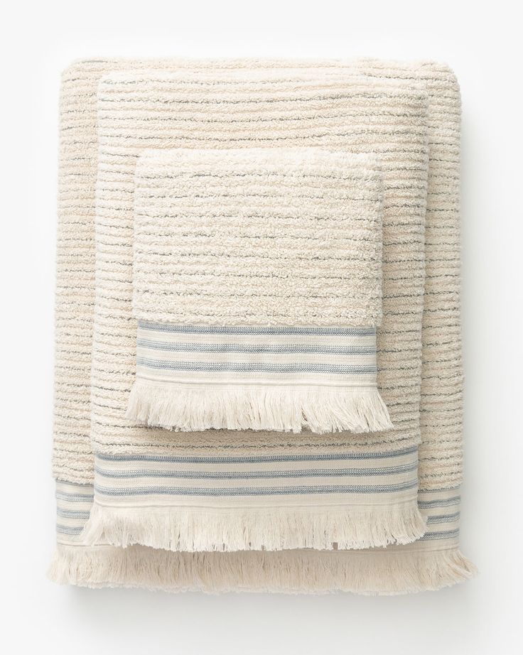 a white and blue blanket with fringes on it