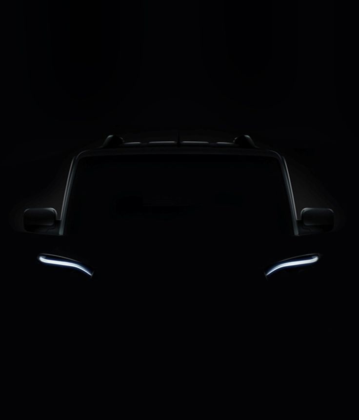 the front end of a black car in the dark