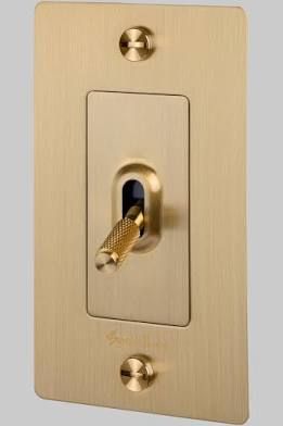 a gold plated light switch with two golden wires on it's side and an outlet in the middle