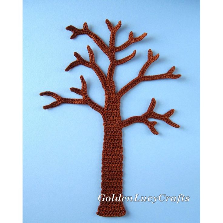 a crocheted tree with no leaves on it is shown against a blue background