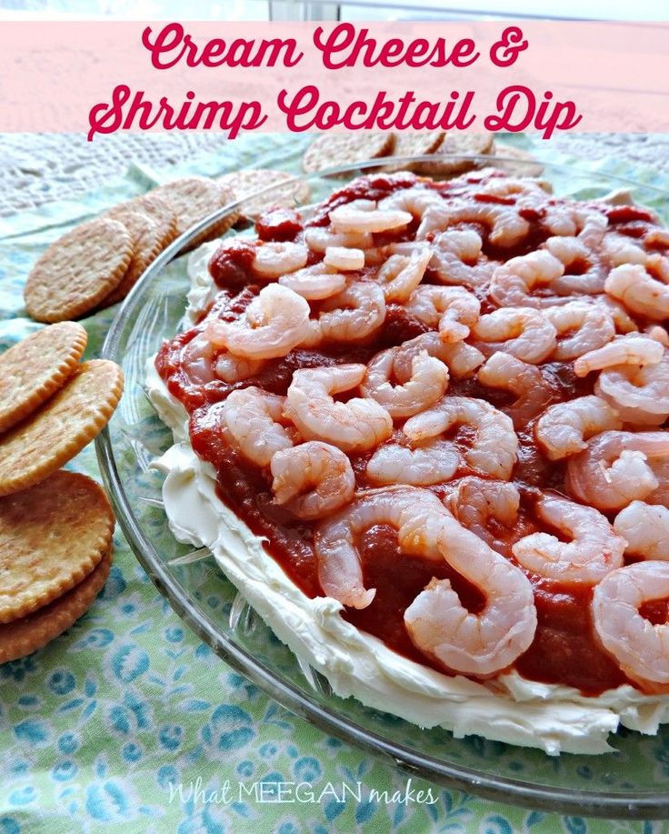 there is a cake with shrimp on it and crackers next to it, along with the words cream cheese and shrimp cocktail dip