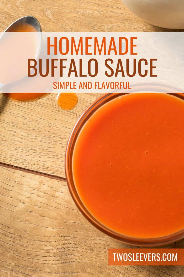 homemade buffalo sauce in a bowl on a wooden table with spoons next to it