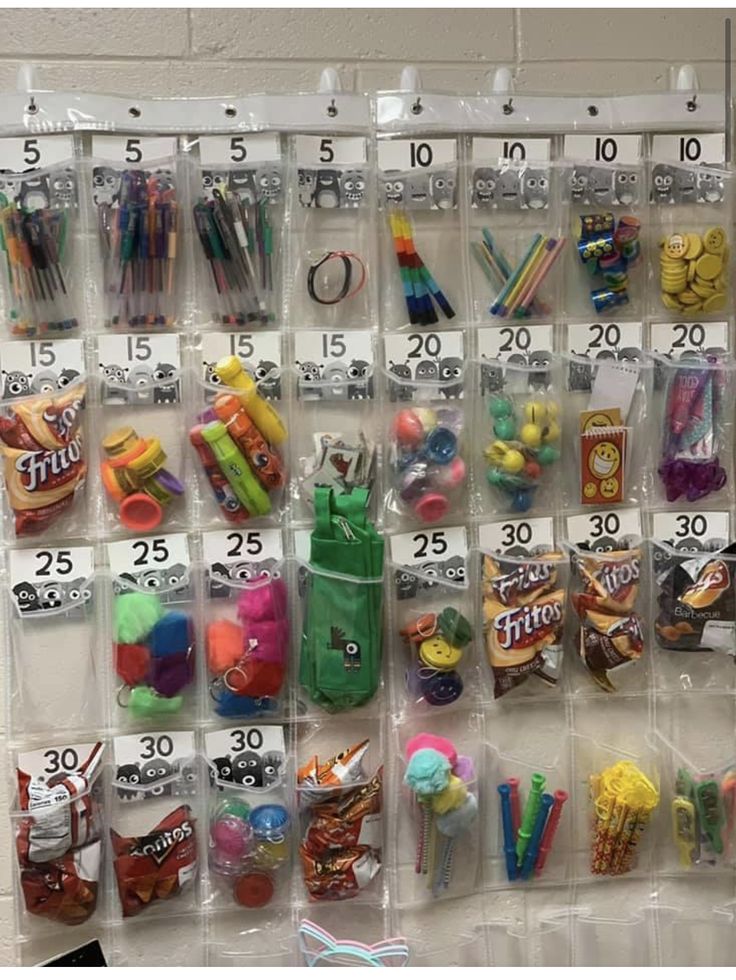 an organized classroom wall hanging with markers, pencils, and other school supplies in plastic bags