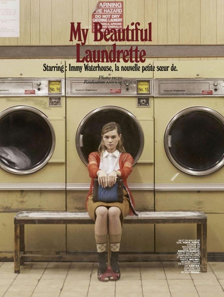 a woman sitting on a bench in front of a washing machine