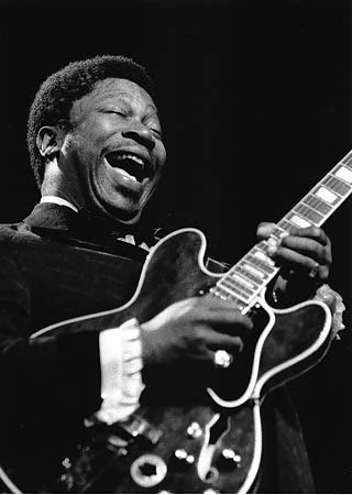 b b king playing guitar with his mouth open