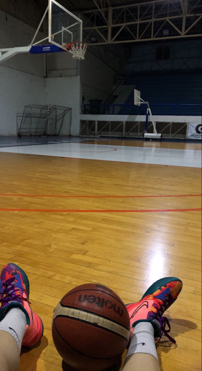 a person laying on the floor with their feet up next to a basketball