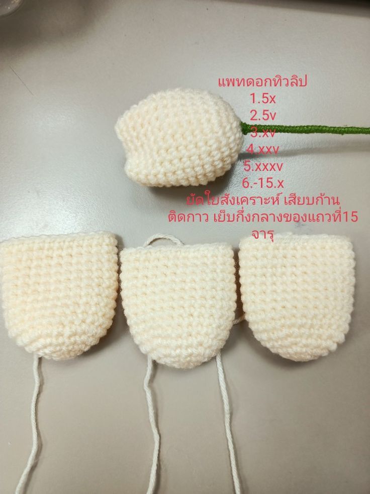 three white knitted objects are shown on a table with string attached to the strings