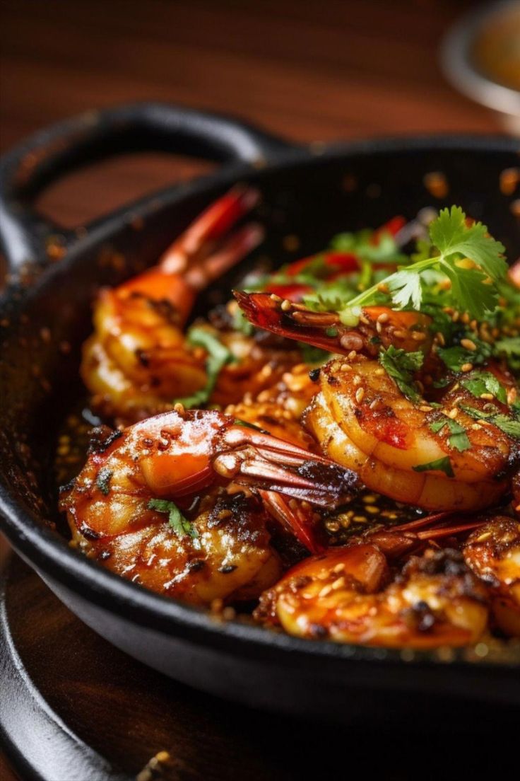 a skillet filled with shrimp and garnished with cilantro