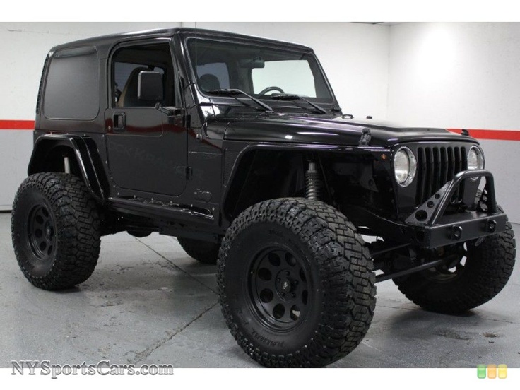 a black jeep is parked in a garage