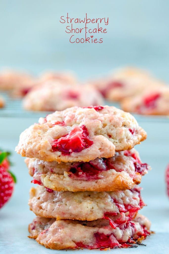 strawberry shortbread cookies stacked on top of each other with fresh strawberries in the background