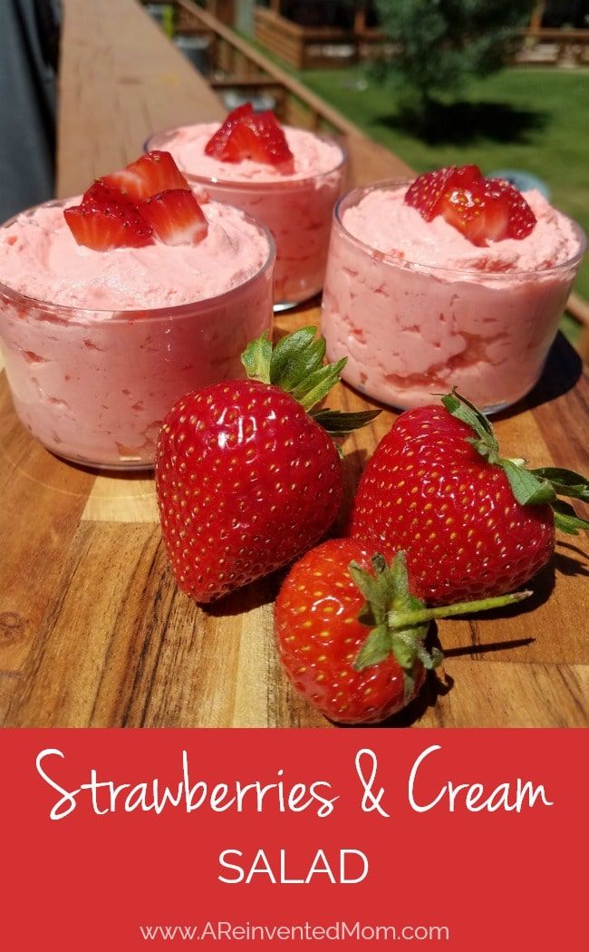 strawberries and cream salad on a cutting board with two strawberrys next to it