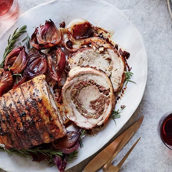 a white plate topped with meat and veggies next to a glass of wine