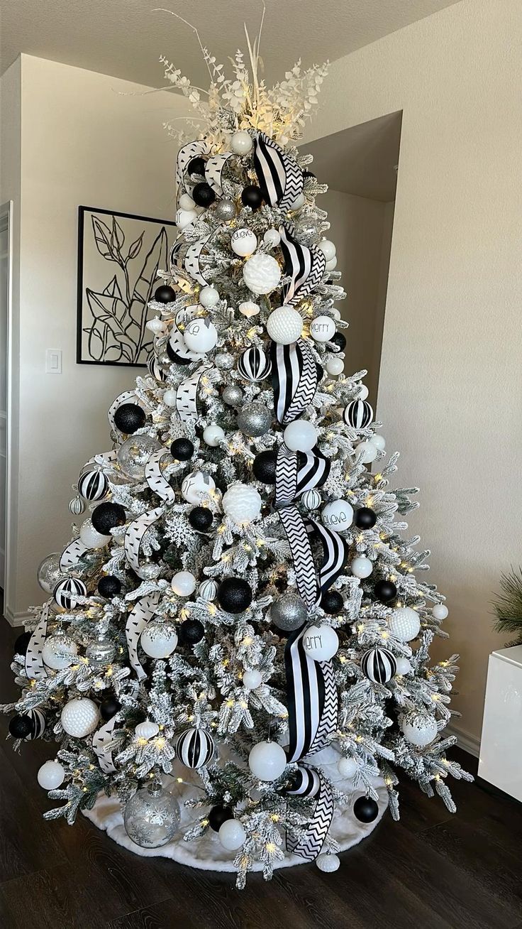 a white christmas tree with black and silver ornaments