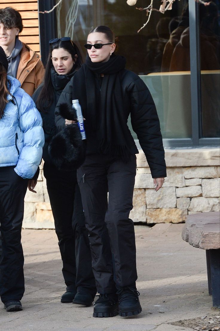 three people walking down the street in winter clothes