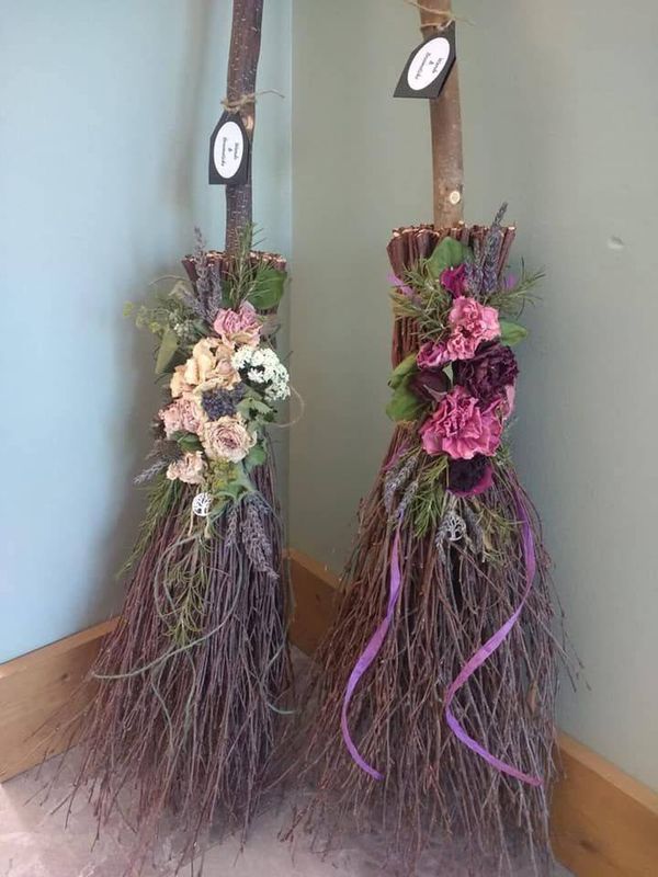 two brooms are decorated with flowers and ribbons