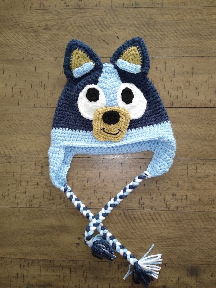 a crocheted blue and white hat with a dog face on it's side