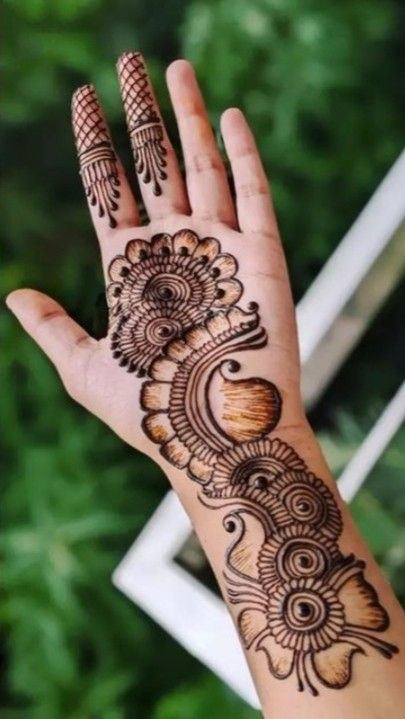 a woman's hand with henna tattoos on it