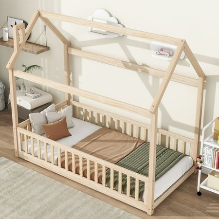 a wooden dollhouse bed in the middle of a room with white walls and wood flooring