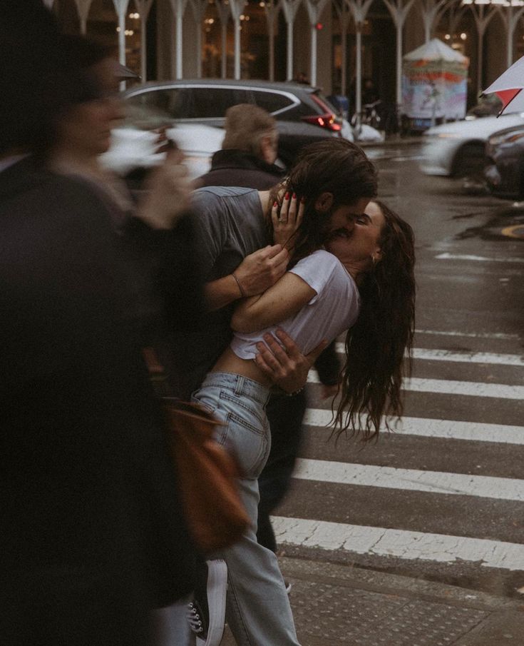 two people hugging each other while crossing the street