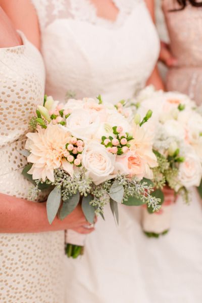 the bridesmaids are holding their bouquets with white and peach flowers on them