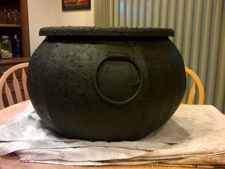 a large black pot sitting on top of a wooden table