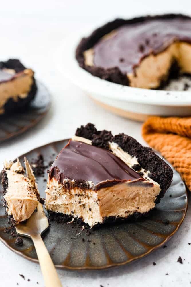 a piece of chocolate peanut butter pie on a plate with a bite taken out of it