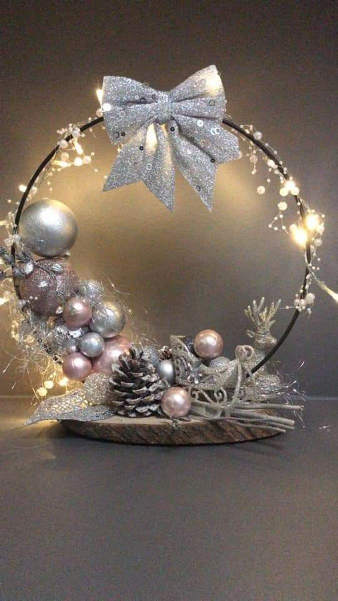 a christmas wreath with lights and ornaments in the shape of a bow on top of it