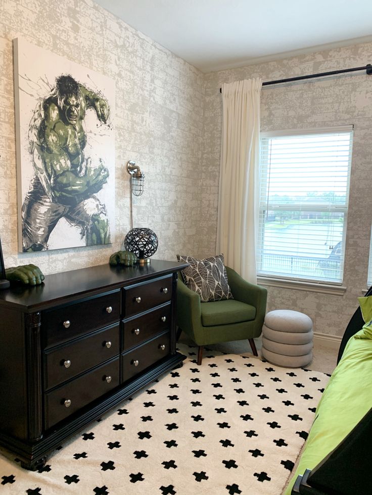 a bedroom with a large painting on the wall and a green chair in front of it