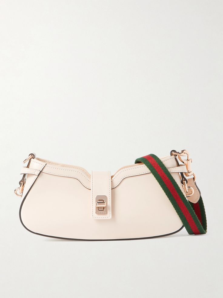 This shoulder bag is unmistakably Gucci thanks to the signature striped webbing strap which is detachable so you can carry it as a clutch, too. It's crafted from smooth cream leather and has a structured curved base and branded gold-tone hardware. Inside, you'll find enough space for your cardholder, mascara and mirror compact. Gucci Cream Shoulder Bag For Travel, Cream Gucci Shoulder Bag For Travel, Modern Gucci Shoulder Bag With Detachable Strap, Elegant Leather Shoulder Bag With Logo Strap, Modern Gucci Shoulder Bag With Detachable Handle, Evening Gucci Shoulder Bag With Detachable Handle, Chic Gucci Shoulder Bag With Top Handle, Elegant Gucci Bags With Adjustable Strap, Chic Gucci Bag With Detachable Strap