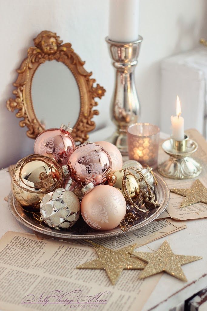 a plate with christmas ornaments on top of a table next to a mirror and candles