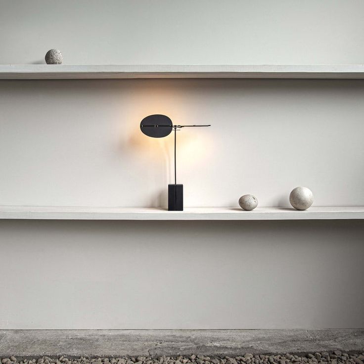 a shelf with three balls and a lamp on it