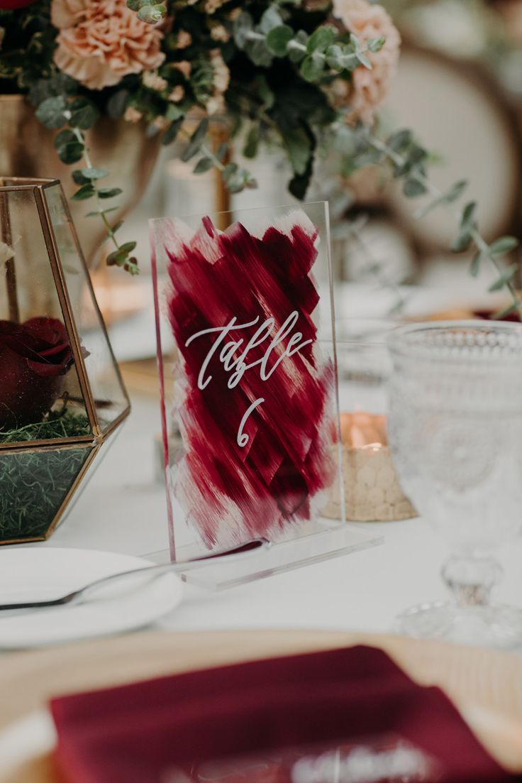 the table is set with place settings and flowers