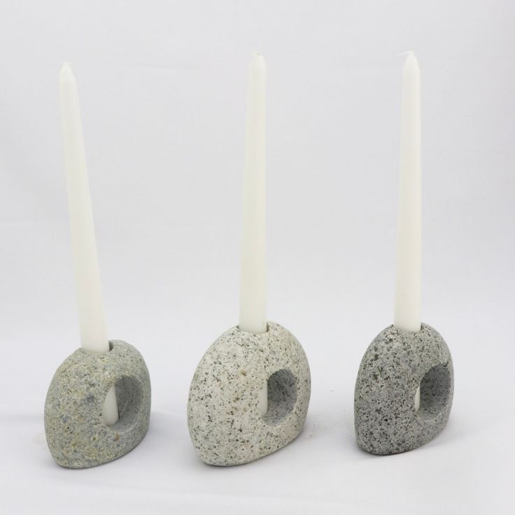 three candles are placed next to each other in the shape of rocks with holes on them