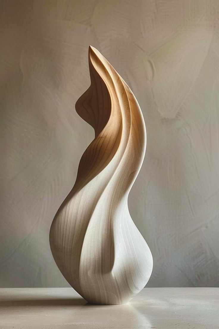 a wooden sculpture sitting on top of a white table next to a gray and beige wall