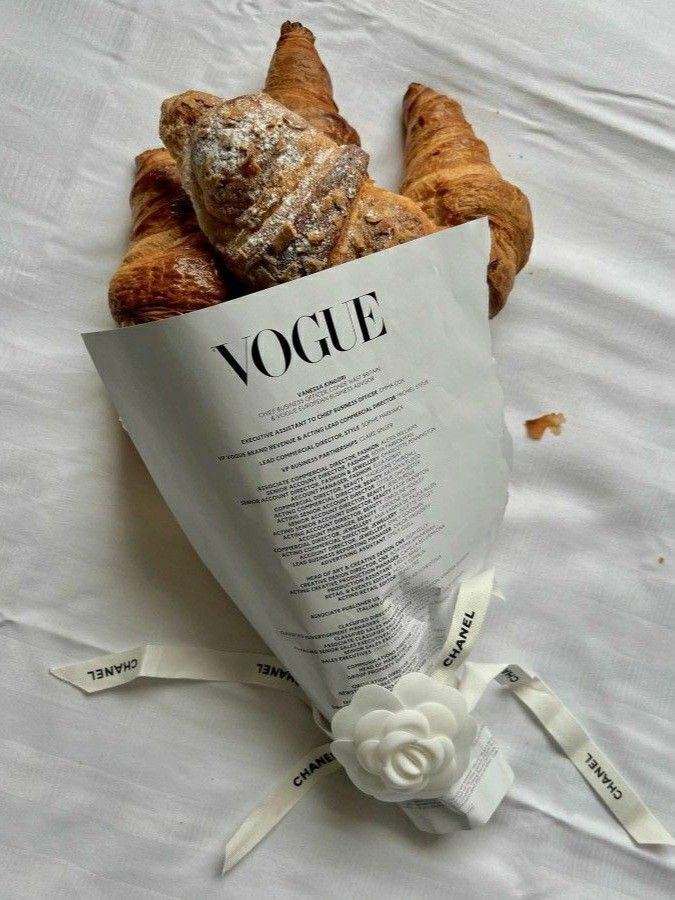 croissants wrapped in paper and tied with ribbon on white bed sheeting