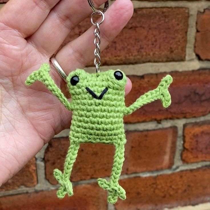 a crocheted keychain with a smiling frog on it