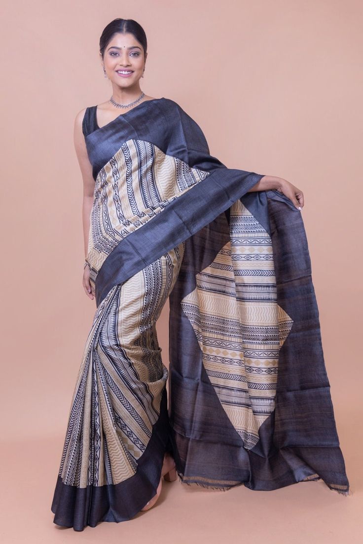 This saree has a tribal inspired motif. It has a bold and original color. We've used tribal patterns in the saree to give a modern look. Our designers didn't compromise with the genuineness of the colors. It is an ideal formal wear. This minimalistic yet original and is ideal for those women who hold a commendable place in society or at work. This handwoven tussar silk saree is the ideal saree to have in your collection. The presence of tussar silk makes this saree incredibly soft and light. Hen Office Wear Saree, Saree In Black, Formal Saree, Khadi Saree, Silk Saree With Blouse, Tussar Silk Saree, Silk Sarees Online, Saree Online, Saree Look