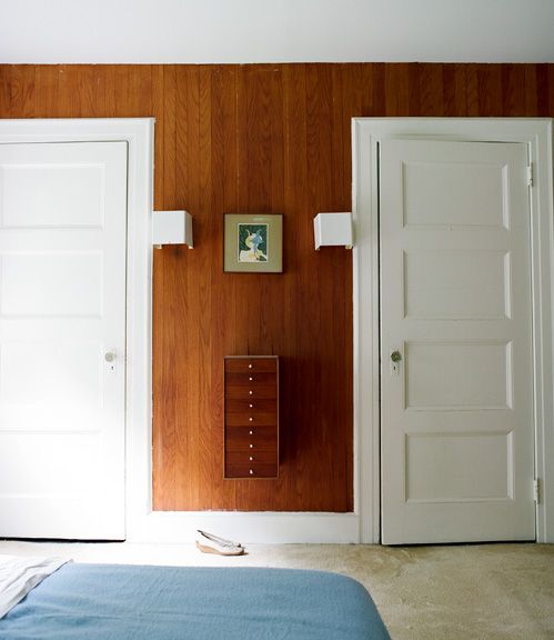 a bedroom with two doors and a bed in the corner next to it is empty