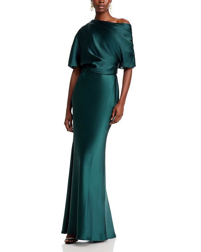 a woman in a long green dress with an off the shoulder top and side slit