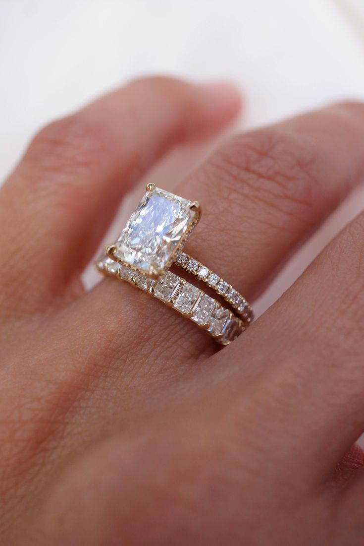 a woman's hand with an engagement ring and wedding band