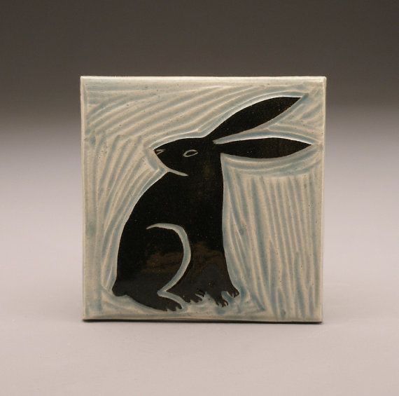 a black and white tile with a rabbit on it