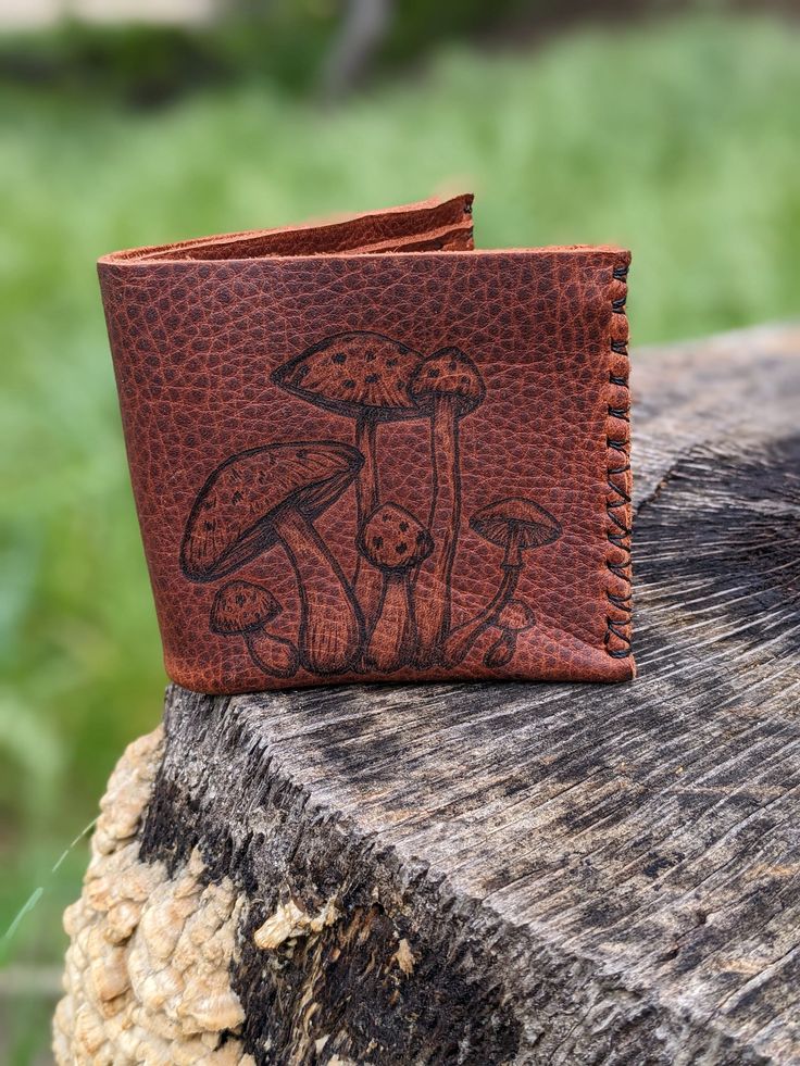 a leather wallet with mushrooms on it