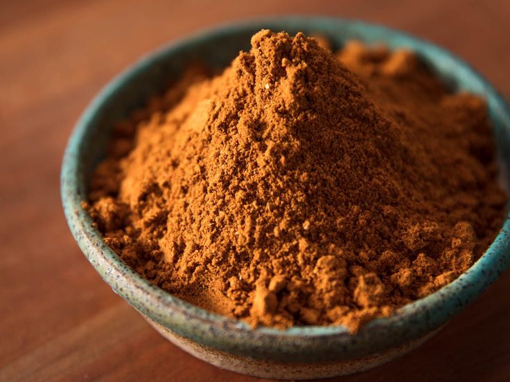 a bowl filled with brown powder on top of a wooden table